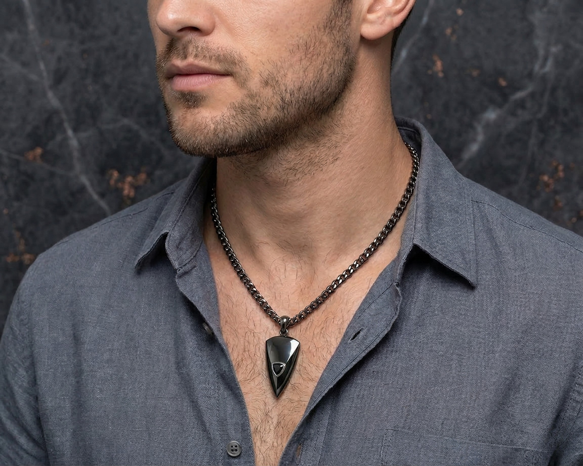 Man wearing the Genghis arrowhead-shaped black diamond pendant with a black finish on a chain