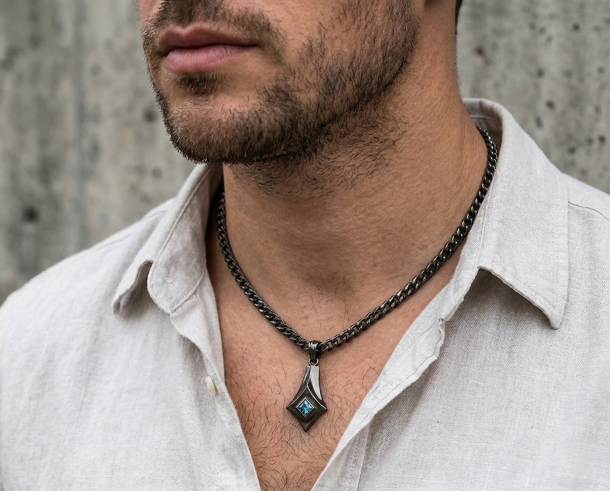 Man wearing the Spartacus geometric blue sapphire pendant with a black finish on a chain